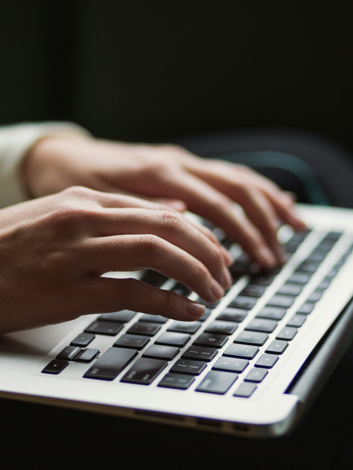 Person typing on a laptop with a dark background